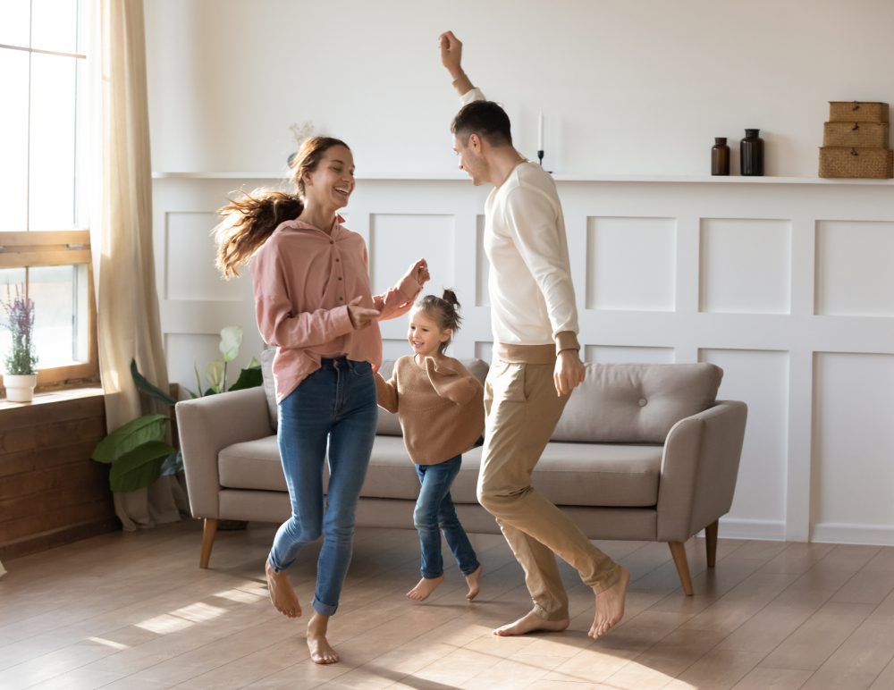 Family dancing joyfully in living room.