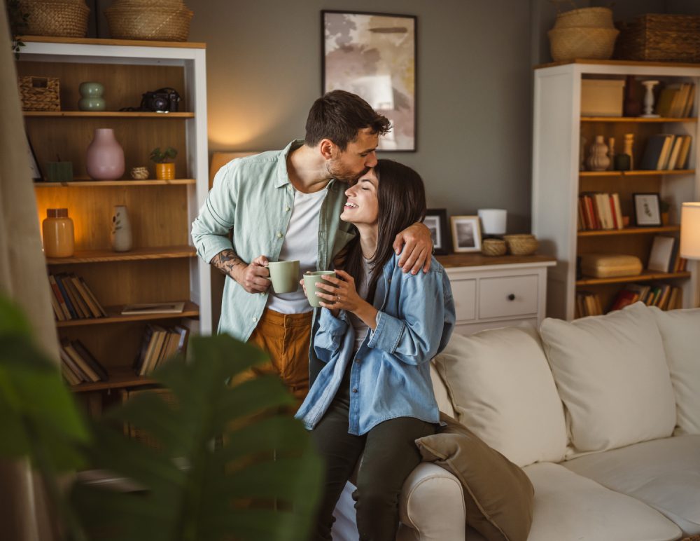 Couple enjoying coffee in cozy living room.