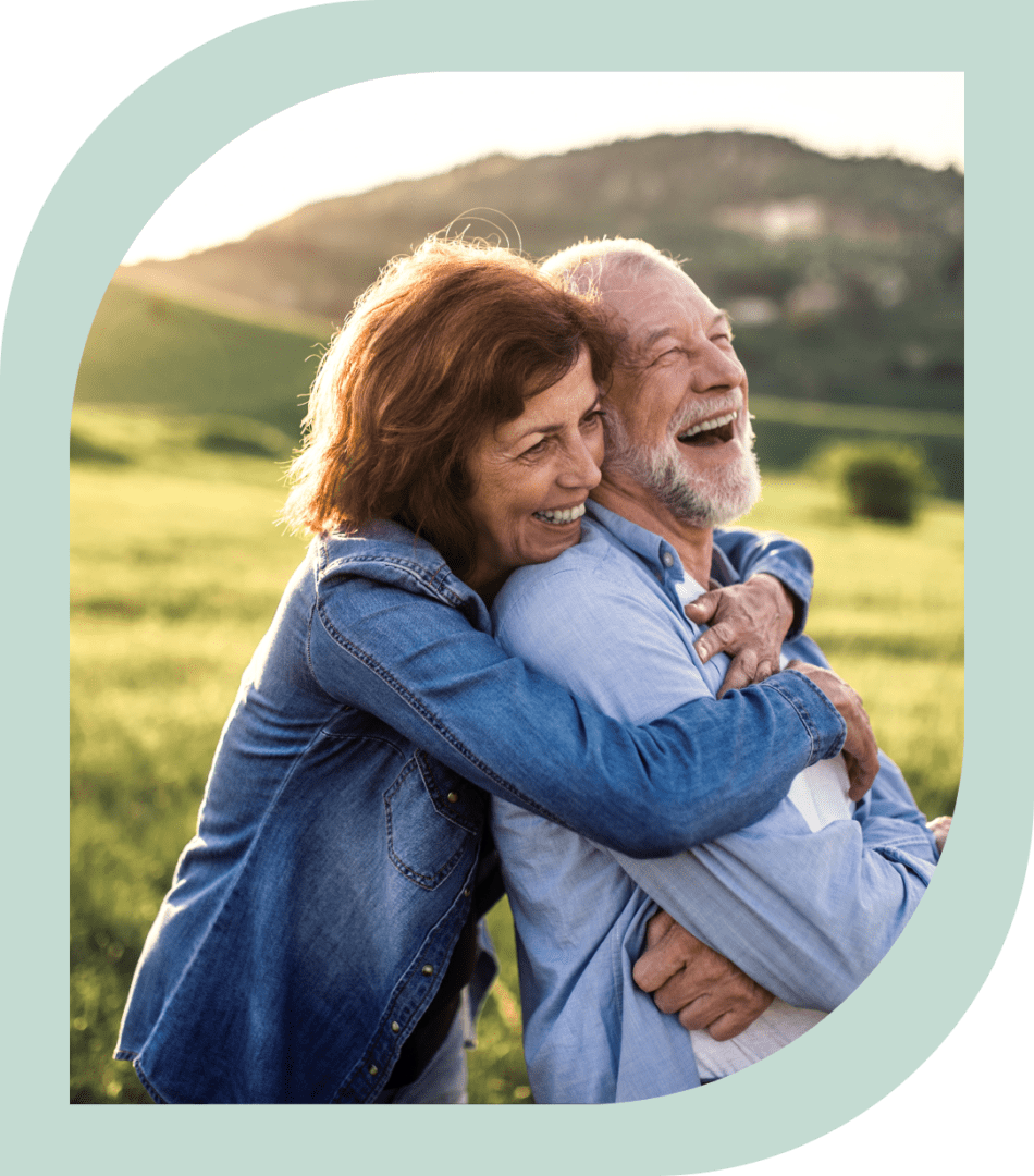 Happy couple embracing in a sunny field.