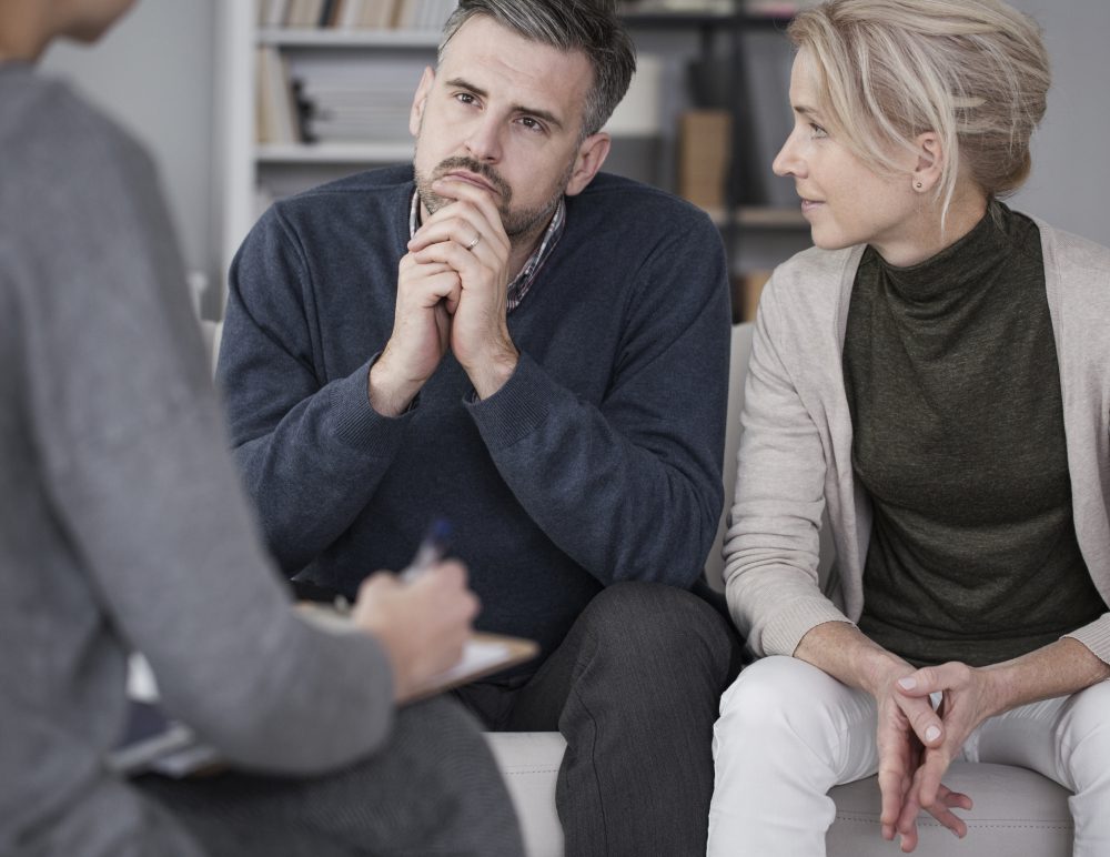 Couple in therapy session with counselor.