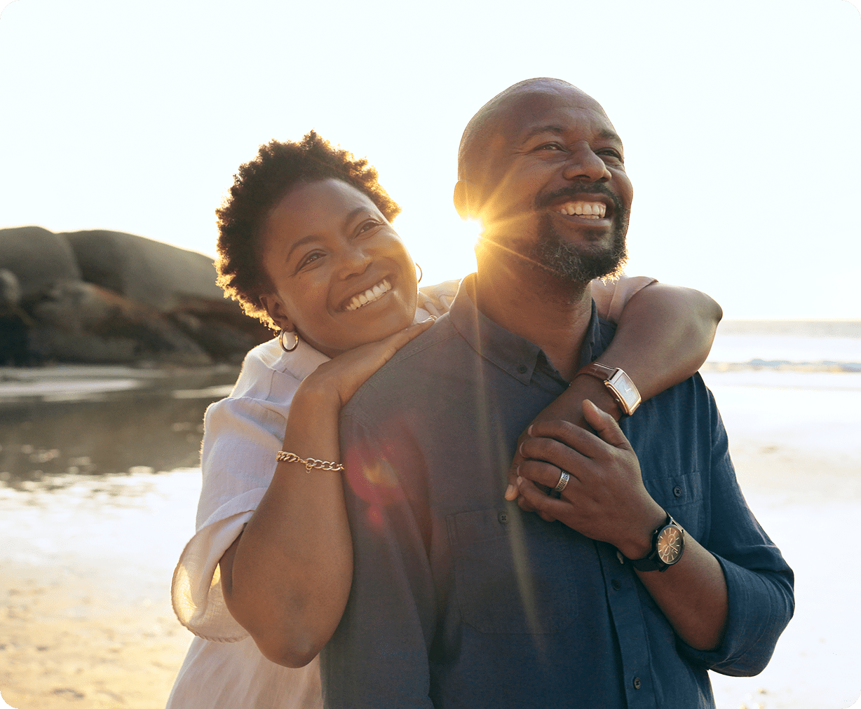 Happy couple embracing on a sunny beach.