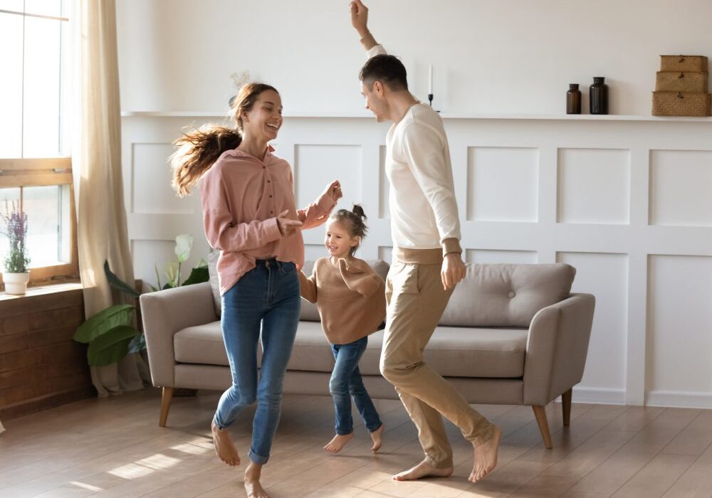 Family dancing joyfully in living room.